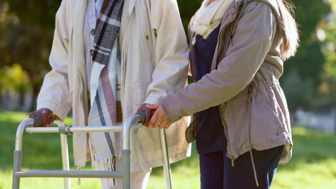 老年妇女，手和助行器与护士在户外花园，公园或大自然中支持锻炼，健康或散步。老人的关怀，幸福和人的帮助