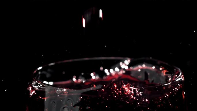 红酒倒进玻璃杯，背景是黑色的。用高速摄像机拍摄，每秒1000帧。