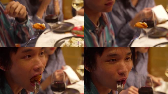 年轻的亚洲华人男人简单地咬了一口，享受着味道