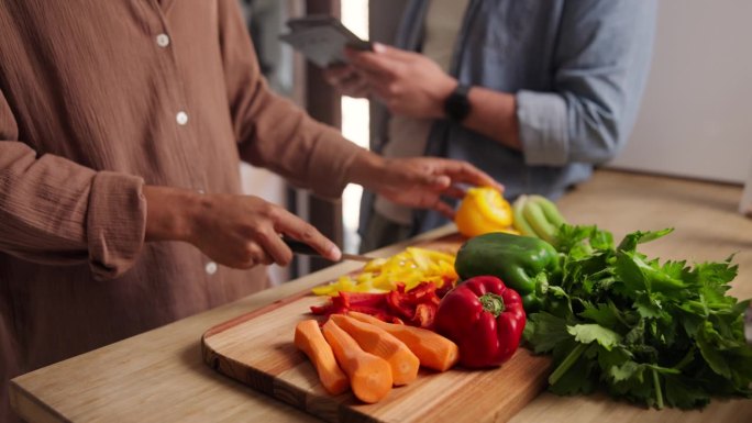 人，手和切蔬菜在船上的健康营养沙拉或晚餐，胡萝卜或胡椒。厨师，助手和平板电脑的在线食谱在厨房准备食材