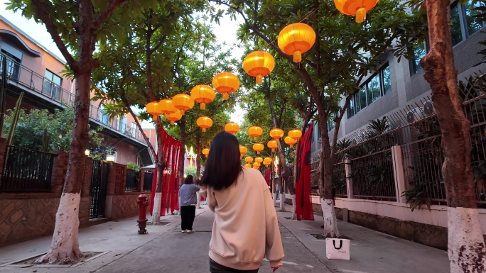 春节灯笼下年轻女子走路的背影