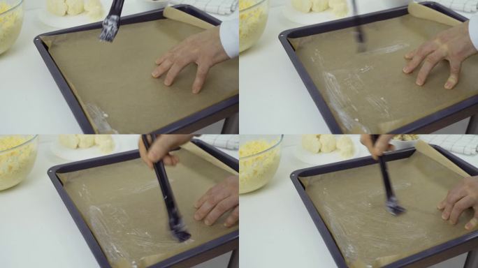 用刷子在烤盘上涂上椰子油，烤盘内衬烤纸。