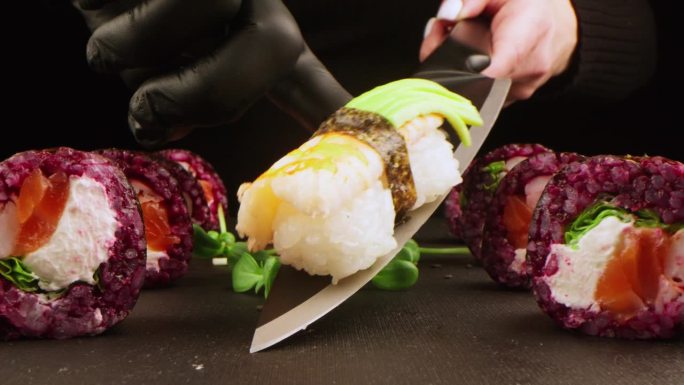 在黑暗的工作室背景下，鲜亮的寿司卷的特写。健康食品的概念，海鲜和新鲜的鱼。寿司菜单，日本料理和亚洲料