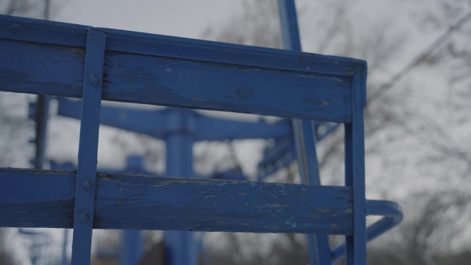 旧的木制滑雪椅、升降椅，漆成蓝色，带有风化的金属杆，秋千，静止