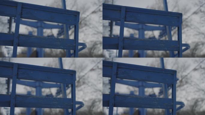旧的木制滑雪椅、升降椅，漆成蓝色，带有风化的金属杆，秋千，静止