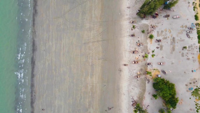 退潮的海浪卷着小木船冲进海滩。风景优美的空中俯瞰在亚洲，孟加拉国