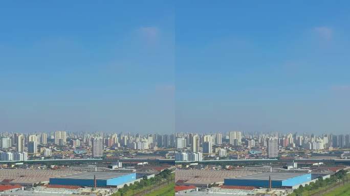 在晴朗的蓝天下，无人机拍摄的现代城市景观