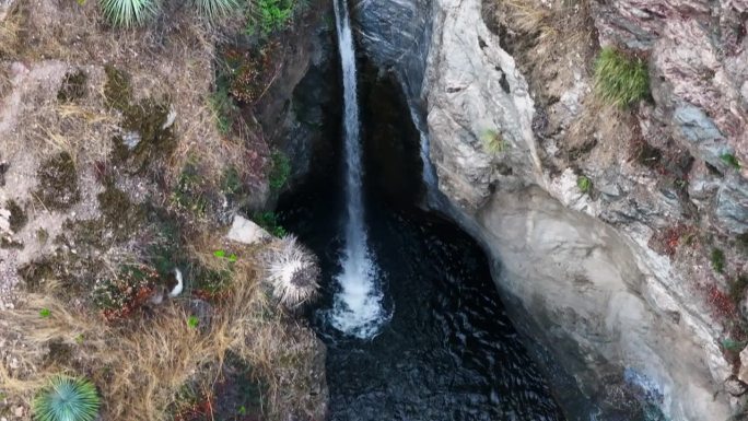 孤独的瀑布进入一个小孤独的池在洛杉矶国家森林加州山区空中自上而下多莉回来