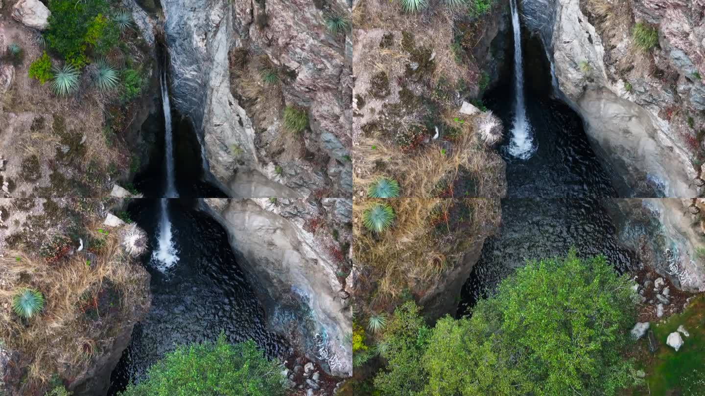 孤独的瀑布进入一个小孤独的池在洛杉矶国家森林加州山区空中自上而下多莉回来