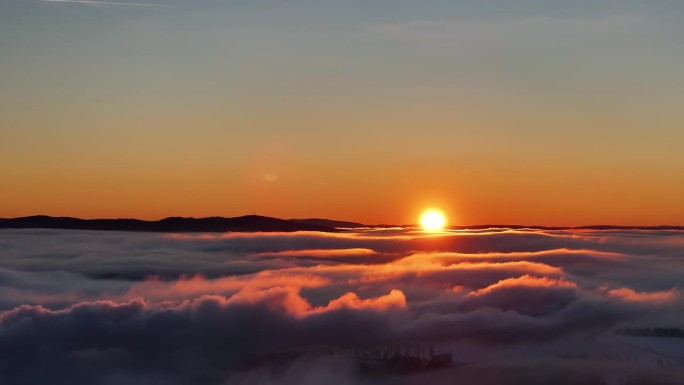 无人机拍摄的史诗级云景在日落时缓慢漂浮在炽热的太阳前