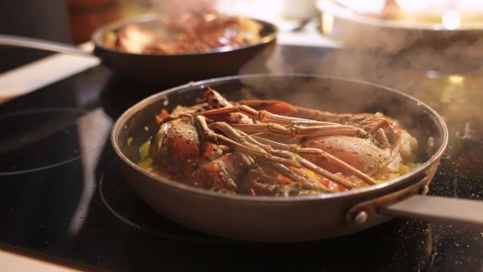 近距离拍摄在电炉上的煎锅上蒸龙虾。加勒比菜中最受欢迎的海鲜