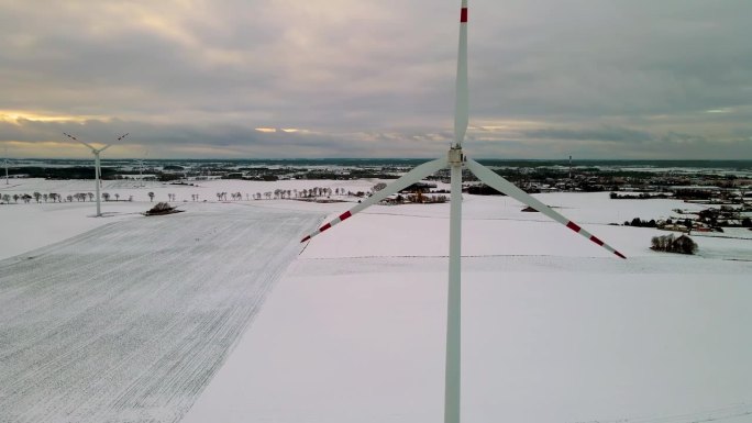风车用大转子风力发电机。现代可再生燃料技术在寒冷的冬季日落与雪