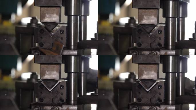 金属变形在行动!在这个动态的库存镜头中，机器精确地切割了建筑元素，生动地展示了工业实力。