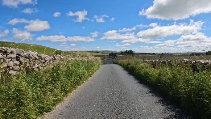 POV:汽车沿着狭窄的柏油路穿过风景秀丽的约克郡乡村