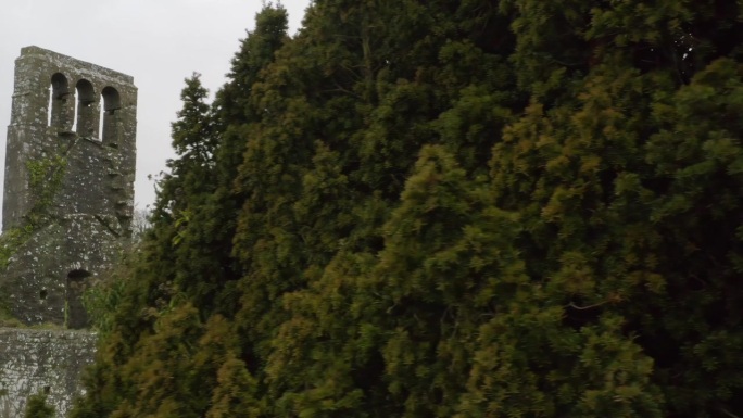 无人机卡车显示墓地的墙壁和墓碑后面的树