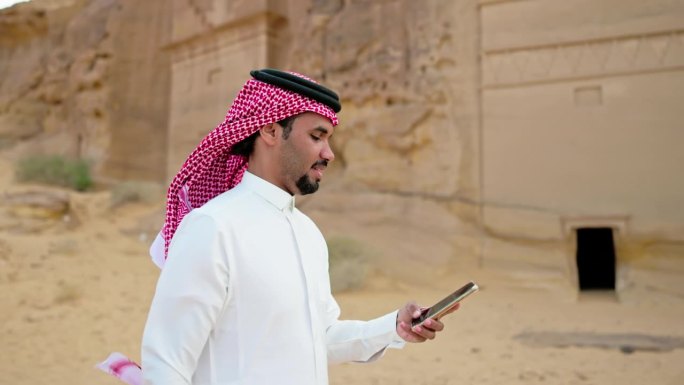 沙特男子在Al-Ula沙漠使用智能手机，慢镜头