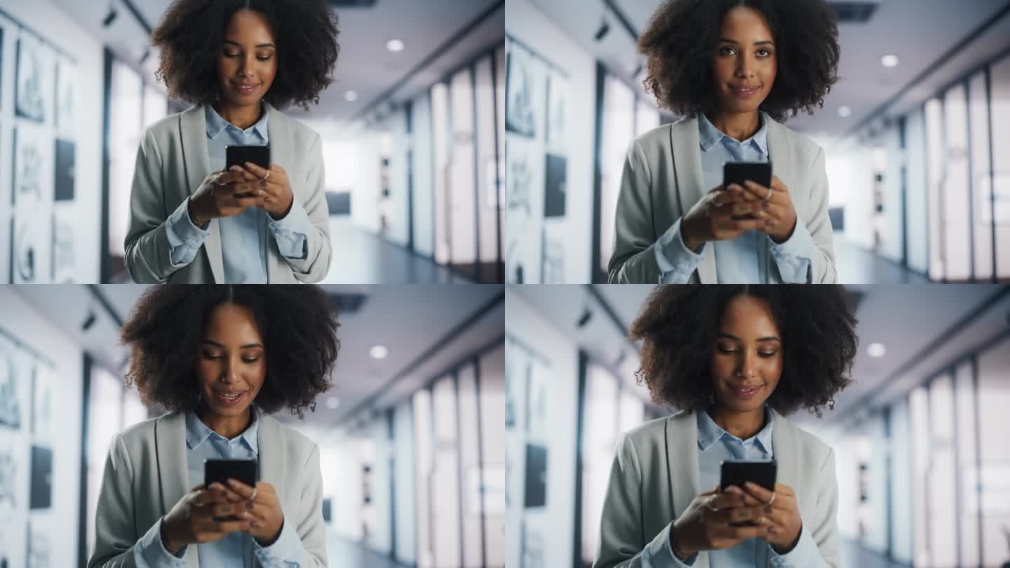 一个微笑的年轻黑人女性在她的智能手机上浏览互联网和社交网络。年轻的女经理查看约会软件，网上购物，给朋