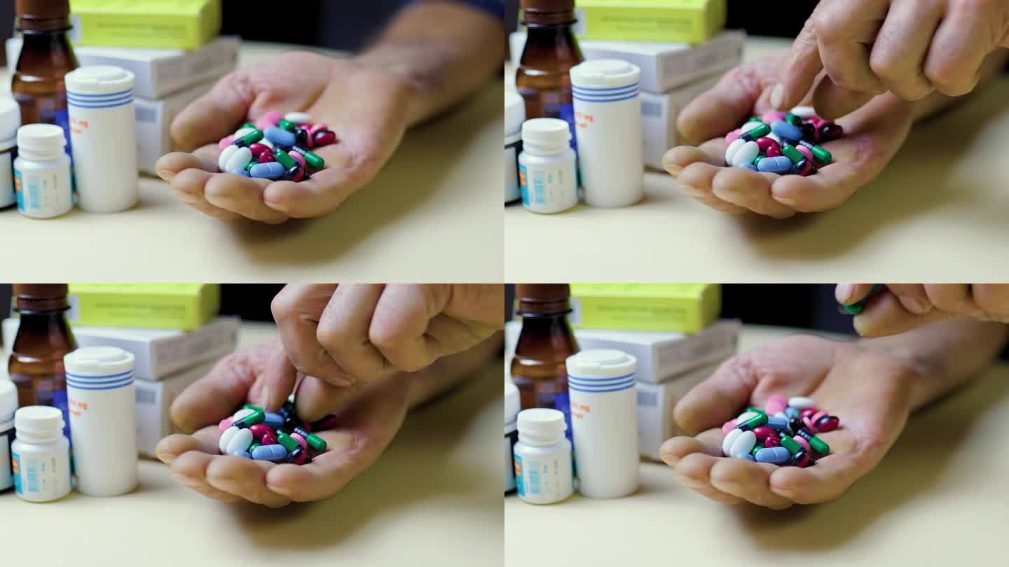 特写:手里握着一把药片，面面相觑，另一只手从手掌中取出一片药片。