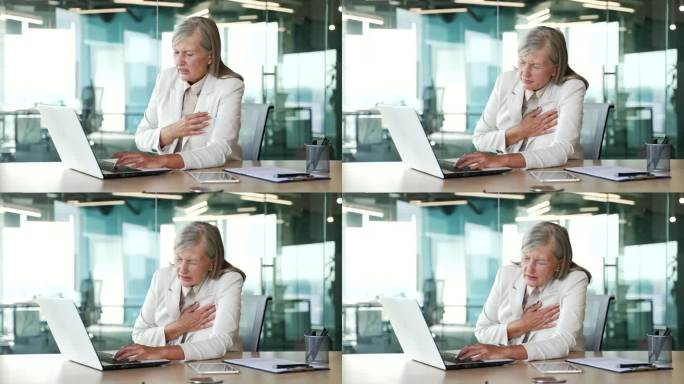 一位白发苍苍的年长女商人在办公室里用笔记本电脑工作时突发心脏病