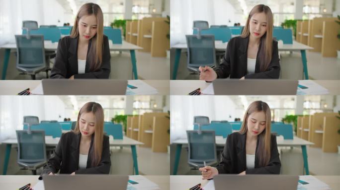 亚洲女商人打开笔记本电脑，从事数据分析项目文书工作。