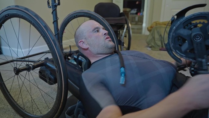 一名身体残疾的男子在家庭健身房使用手动自行车
