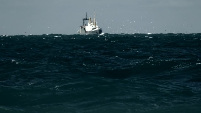 在暴风雨中捕鱼海浪中的渔船海浪起伏海浪冲