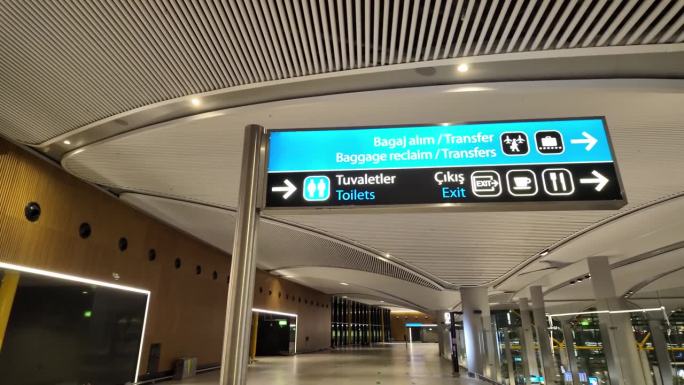 伊斯坦布尔机场的灯光招牌上写着行李提取、转机、厕所和出口。