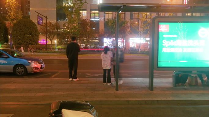 城市夜晚公交站台等车的人们人流延时