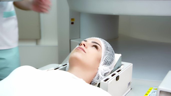 在医学实验室里，男放射科医生对正在接受手术的女病人进行核磁共振或CT扫描。高科技现代医疗设备。