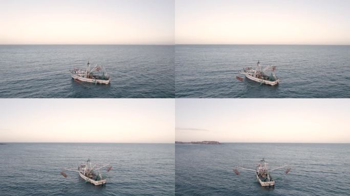 航拍无人机拍摄的捕虾船在日落时捕鱼。