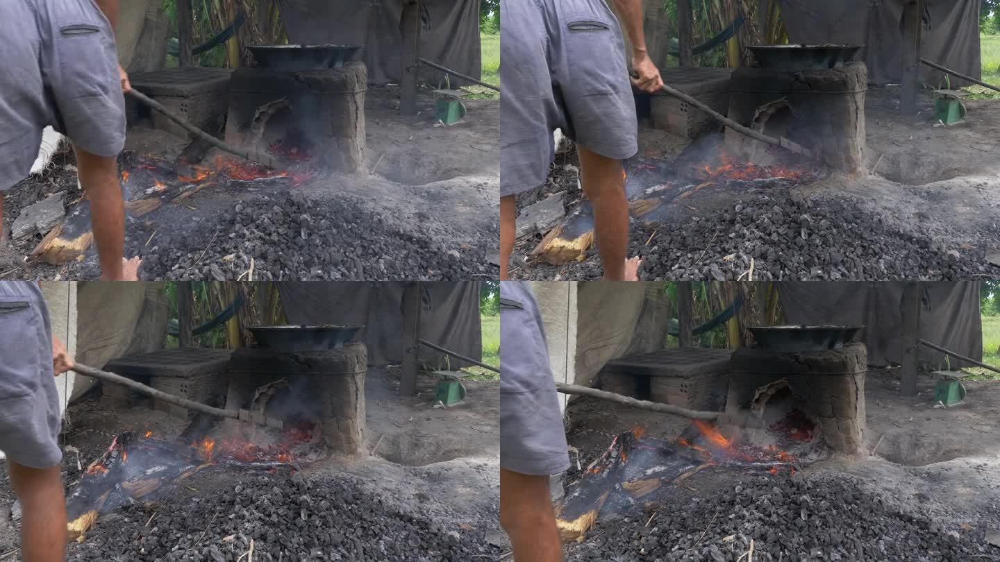 一个男人的背影，从石炉下取出最后残余的烧过的木头