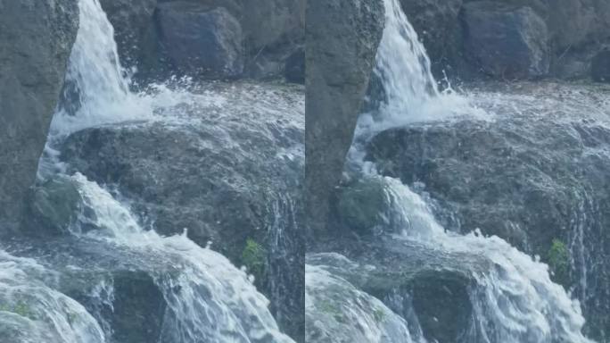 瀑布在岩石上奔流，白色的水花飞溅