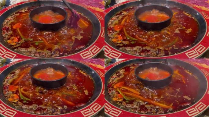 热腾腾的两味四川火锅配辣味番茄汤，筷子滴入牛肉、香菇、鲜牛肚和虾饺