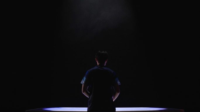 男人乒乓球比赛站在乒乓球桌前抬头背影