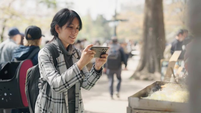 有魅力的女人喜欢在露天市场点餐，然后拿出手机拍照。