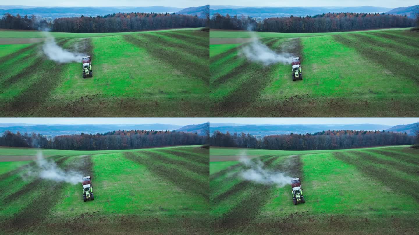 空中:拖拉机将肥料撒在农田的灰化土上，以提高产量