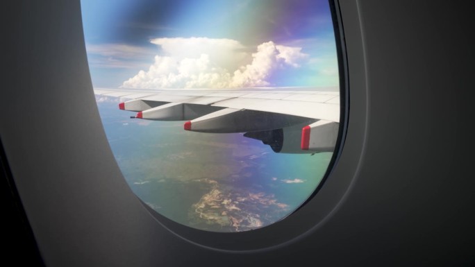从飞行中的客机窗口向外望去，可以看到广阔的天空全景，汹涌的云层一直延伸到眼睛所能看到的地方，旅行和航