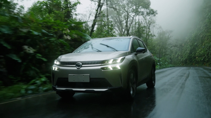 航拍新能源汽车行驶在森林公路上