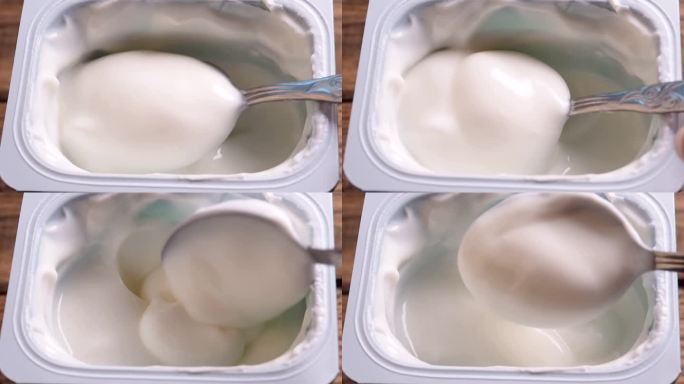 用勺子搅拌酸奶的特写，乳制品。