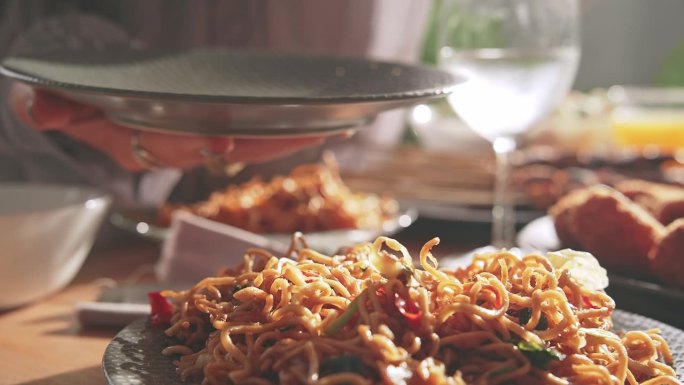 餐桌上的新鲜亚洲美食。以东方产品为原料的亚洲烹饪配方概念。对妇女用竹签手拿植物油炒面的看法