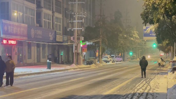 夜晚下雪的城市街道人流