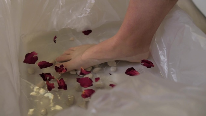 女人赤脚踩在水桶与花瓣慢动作，水疗宠爱