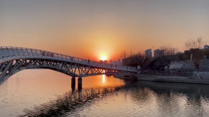 落日余晖铁架桥河流散步的人变焦