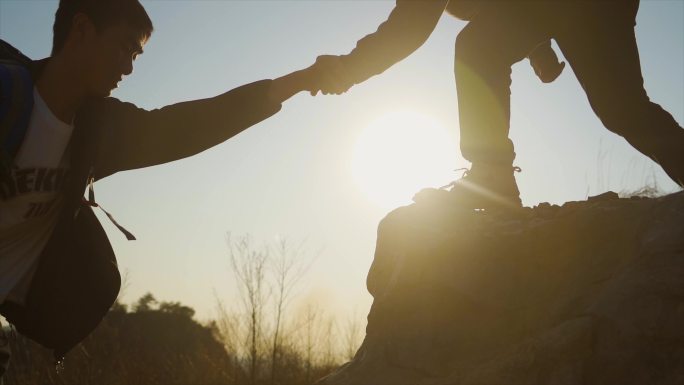 团队协作手拉手登山户外爬山团队精神攀登者