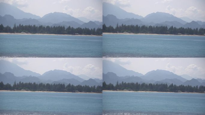 4k的海洋视频，背景是层层叠叠的蓝山。可以看到海、山和天空