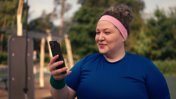 体型庞大的女性滚动智能手机应用程序，搜索街头健身提示