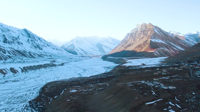 4K鸟瞰图，白雪覆盖的喜马拉雅山脉和印度斯皮蒂山谷结冰的斯皮蒂河。印度喜马拉雅山脉，河流和小村庄的自