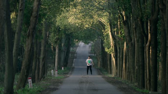 男子在幽静的林间小道跑步锻炼身体