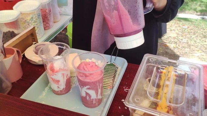过程视频是呈现新鲜的冰沙饮料与草莓和奶油口味和磨碎的奶酪浇头