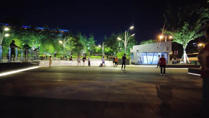 夜晚公园广场休闲散步跳舞的人们